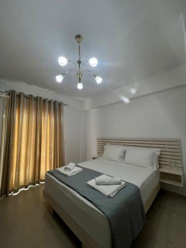 a bedroom with a large bed and a chandelier at Athina Rooms in Himare