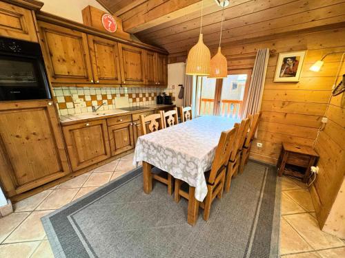 une cuisine avec une table et quelques placards en bois dans l'établissement Les Chalets Du Doron - Bel appartement dans les 3 Vallées MAE-4504, à Praranger