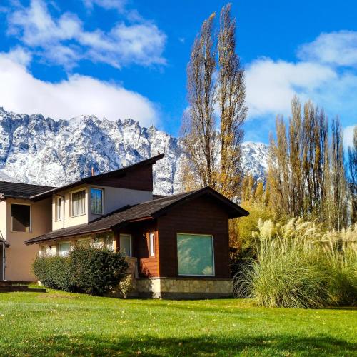 una casa con le montagne sullo sfondo di La Aguada a El Bolsón