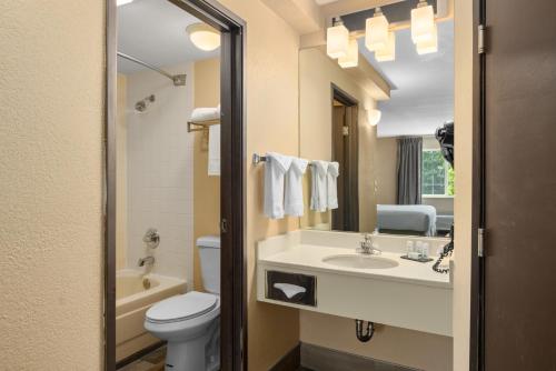 a bathroom with a sink and a toilet and a mirror at Ramada by Wyndham Portland in Portland