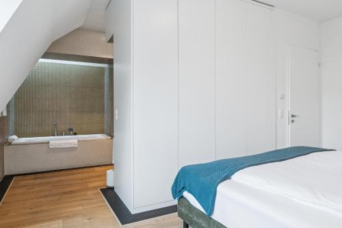 a bedroom with a bed and a bath tub at Horizon Home Löwenstrasse Penthouse in Zürich