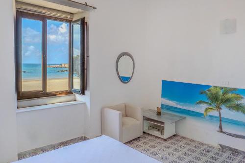 a bedroom with a view of the beach from a window at Casa Mare in Marina di Casalvelino