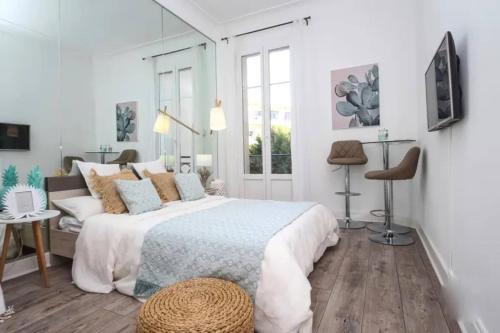 une chambre blanche avec un grand lit et une fenêtre dans l'établissement MIRAMAR-Studio tout confort sur la croisette, à Cannes