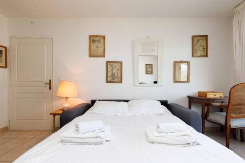 une chambre avec un lit avec des serviettes dessus dans l'établissement PALMIER Calme, 2 chambres, 2 salle de bains, 2 wc, clim, Parking, à Cannes