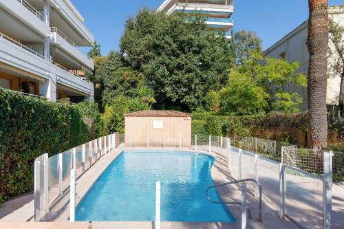 une piscine au milieu d'un immeuble dans l'établissement PALMIER Calme, 2 chambres, 2 salle de bains, 2 wc, clim, Parking, à Cannes