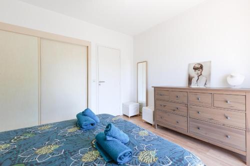 une chambre avec un lit avec des oreillers bleus dessus dans l'établissement MALTE-Entrée Cap d'Antibes, perle tout confort - Rare, à Antibes