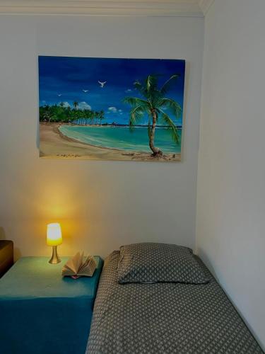 - une chambre avec un lit et une photo de la plage dans l'établissement Les Caroubiers, à Roquebrune-Cap-Martin