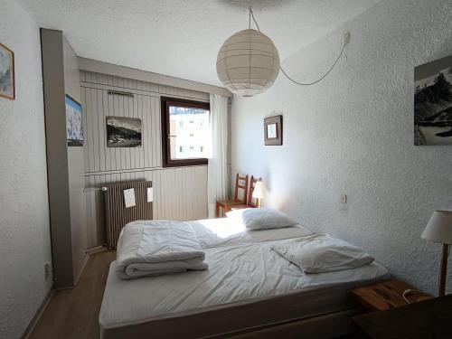 - une chambre avec un lit et une lampe pendant dans l'établissement Résidence Loubatiere - Grand appartement pour 8 personnes MAE-8264, à Montgenèvre
