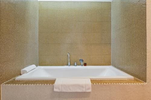 a bathroom with a bath tub with a sink at Horizon Home Löwenstrasse Penthouse in Zürich