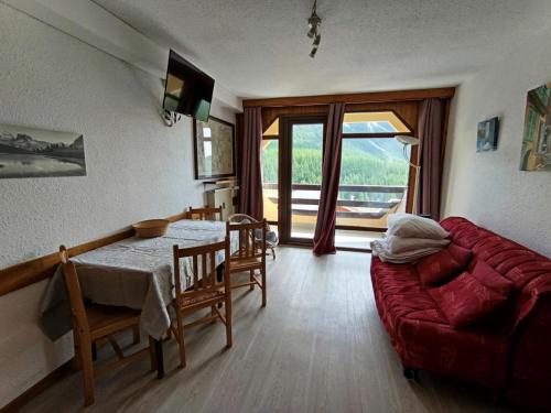 a living room with a red couch and a table at Résidence Olympia 2000 - Studio 4 à 5 personnes - Vue imprenable MAE-8464 in Montgenèvre