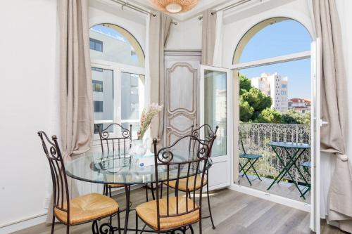 d'un balcon et d'une salle à manger avec une table et des chaises en verre. dans l'établissement JASMIN-Très chic 2 pièces, wifi, clim à 200 m Croisette, à Cannes