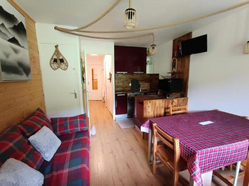 un salon avec une table et un canapé dans l'établissement Résidence Ferme D'augustin - Batiment C - Appartement rénové plein sud avec parking et sur les pistes de ski MAE-8484, à Montgenèvre