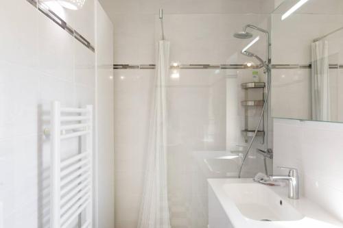 une salle de bain blanche avec un lavabo et une douche dans l'établissement JASMIN-Très chic 2 pièces, wifi, clim à 200 m Croisette, à Cannes