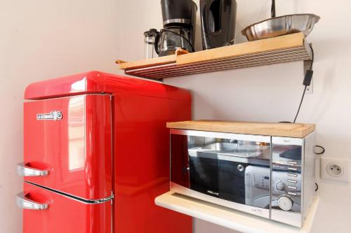 un micro-ondes rouge à côté d'un réfrigérateur rouge dans l'établissement ORIENT Ecrin moderne ,tout confort, 300 m Croisette, à Cannes