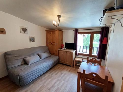 un salon avec un canapé et un bureau dans l'établissement Résidence Neige Et Golf - Petit studio cosy sans balcon exposé Nord mais en front de neige ! MAE-8854, à Montgenèvre