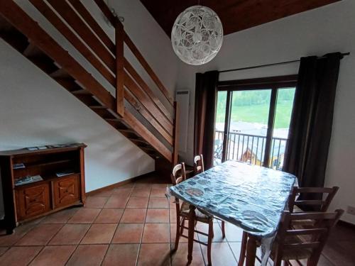 une salle à manger avec une table et un escalier dans l'établissement Résidence Korossol - Joli duplex au coeur du village MAE-8634, à Montgenèvre