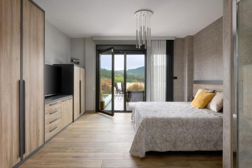 a bedroom with a bed and a flat screen tv at Casa con Vistas al Paisaje y Encanto en el Corazón del País Vasco,España in Mungia