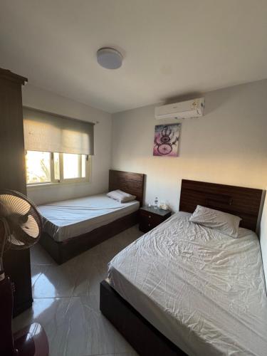 a bedroom with two beds and a window at Golden Sands in El Alamein