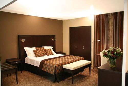 Habitación de hotel con cama y silla en Hotel Malon, en Lovaina