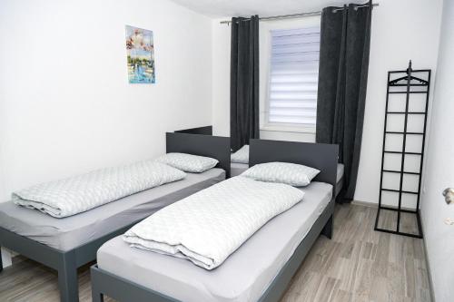 two beds in a room with a window at Apartman Castello in Jajce