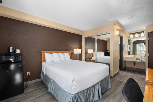 a hotel room with a large bed and a bathroom at Ramada by Wyndham Portland in Portland