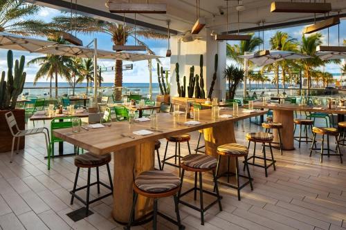 a restaurant with tables and chairs and the ocean at High Floor Luxury 2BR 2BA, Sleeps 6, Resort Access - Horizon by HomeStakes Stays in Fort Lauderdale