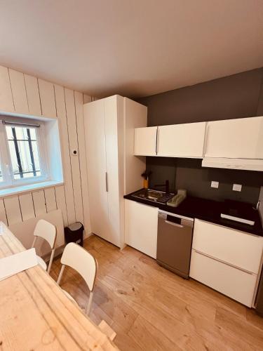 a kitchen with white cabinets and a table and chairs at Appartement Biarritz plage Milady surf in Biarritz