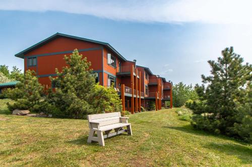a bench sitting in the grass in front of a building at Incredible Views w Garage on Lake and bike trail in Tofte