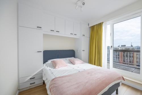 オーステンデにあるSunset Beach 7のベッドと大きな窓のある寝室