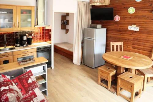 une petite cuisine avec une table et un réfrigérateur dans l'établissement Résidence Les Ecrins - 403 LES ECRINS STUDIO 5 PERSONNES MAE-2423, aux Orres