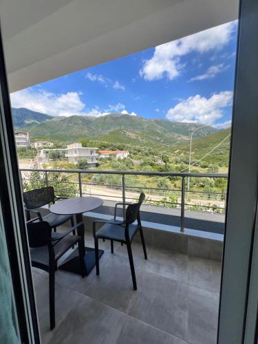 a balcony with a table and chairs and a view at Athina Rooms in Himare
