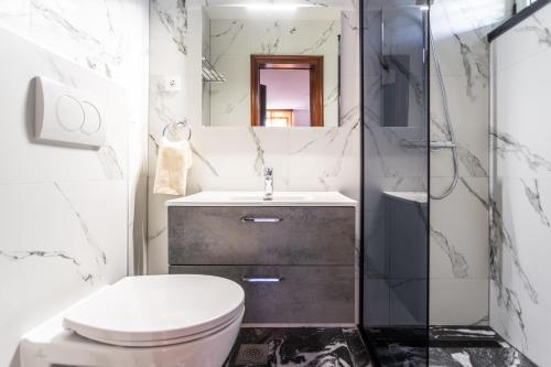 een badkamer met een wastafel, een toilet en een spiegel bij Beautiful luxury house w sea view & outside space in Split