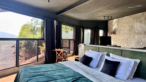 a bedroom with a bed with a large window at 1819 Marine Hotel in Ubatuba