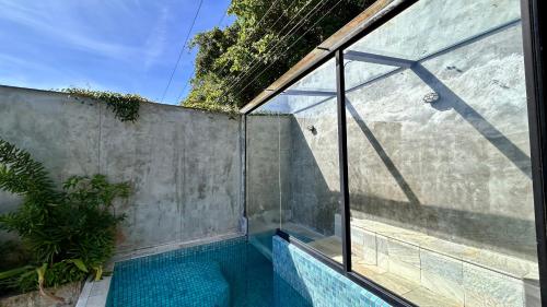 an indoor swimming pool with a glass wall at 1819 Marine Hotel in Ubatuba