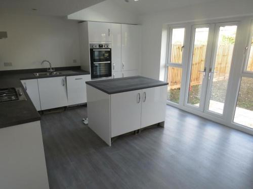a kitchen with white cabinets and a black counter top at Tradewinds Integrated Services Ltd in Peterborough