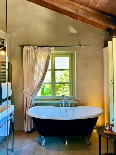 a bath tub in a bathroom with a window at MiaClara Relais in Alba