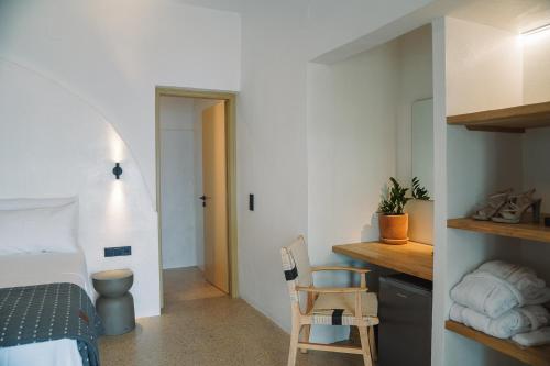 a bedroom with a bed and a desk with a chair at Cape Napos in Faros