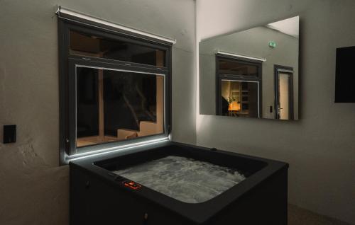 a bath tub in a room with a window at Cape Napos in Faros