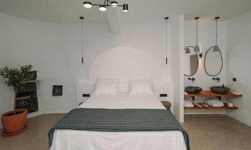 a bedroom with a bed with two mirrors on the wall at Cape Napos in Faros