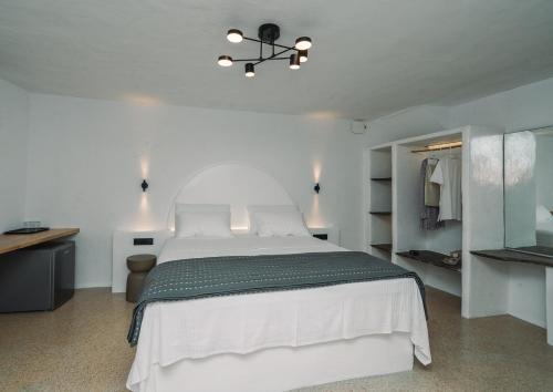 a bedroom with a large white bed and a chandelier at Cape Napos in Faros
