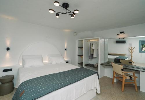 a bedroom with a white bed and a desk at Cape Napos in Faros