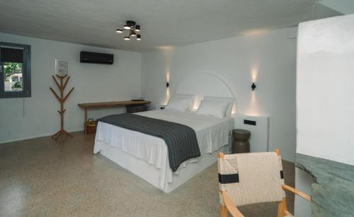 a bedroom with a white bed and a table at Cape Napos in Faros