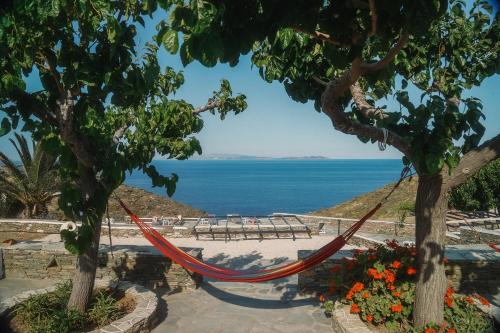 a hammock hanging between two trees on a beach at Cape Napos in Faros