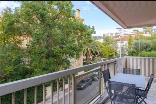 un porche avec une table et des chaises sur un balcon dans l'établissement ESCURIAL Bel appart rénové proche Croisette et plage, à Cannes