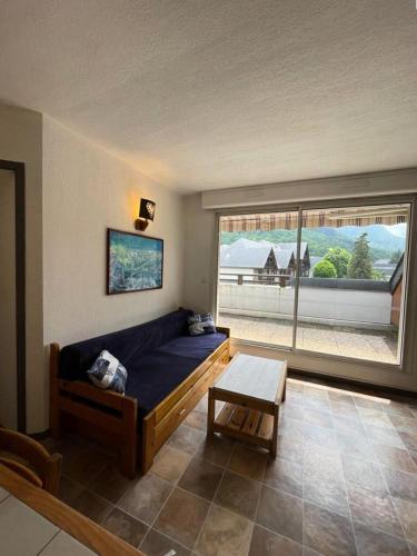 un salon avec un canapé et une grande fenêtre dans l'établissement Résidence Ondines - Appartement en duplex 4-6 Personnes au cœur du village MAE-6673, à Saint-Lary-Soulan