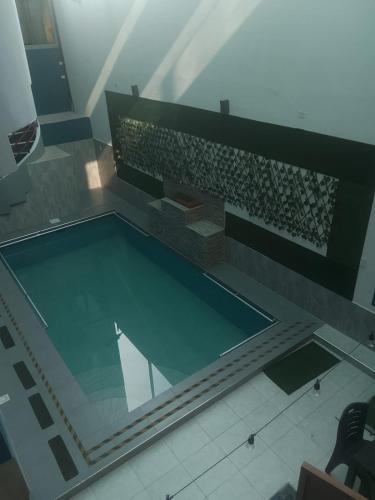 a swimming pool in a building with a table at Hotel Samay Wasi in Tacna