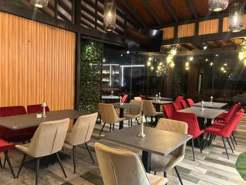 a dining room with tables and red chairs at Hotel San Benito Cuenca in Cuenca