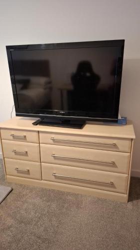 a flat screen tv sitting on a dresser at Tradewinds Integrated Services Ltd in Peterborough