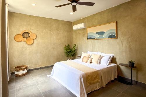 a bedroom with a bed and a ceiling fan at Villavida Boutique Hotel - La Playita in Las Galeras