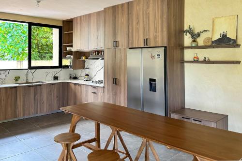 a kitchen with a wooden table and a refrigerator at Villavida Boutique Hotel - La Playita in Las Galeras